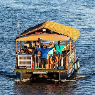 People on a small boat with straw roof, waving on a sunny day.