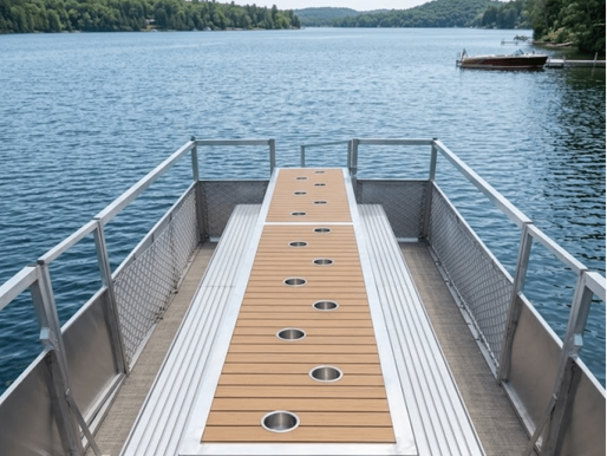 Top view of a pontoon boat docked on a scenic lake with distant trees.